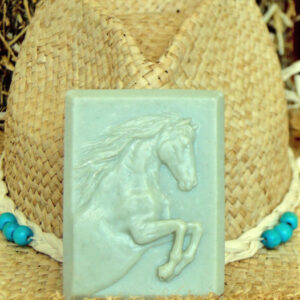 balsam fir soap with French green clay rearing horse design handmade in front of a cowgirl hat