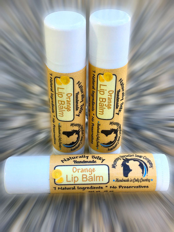 orange lip balms in white plastic tubes with labels.